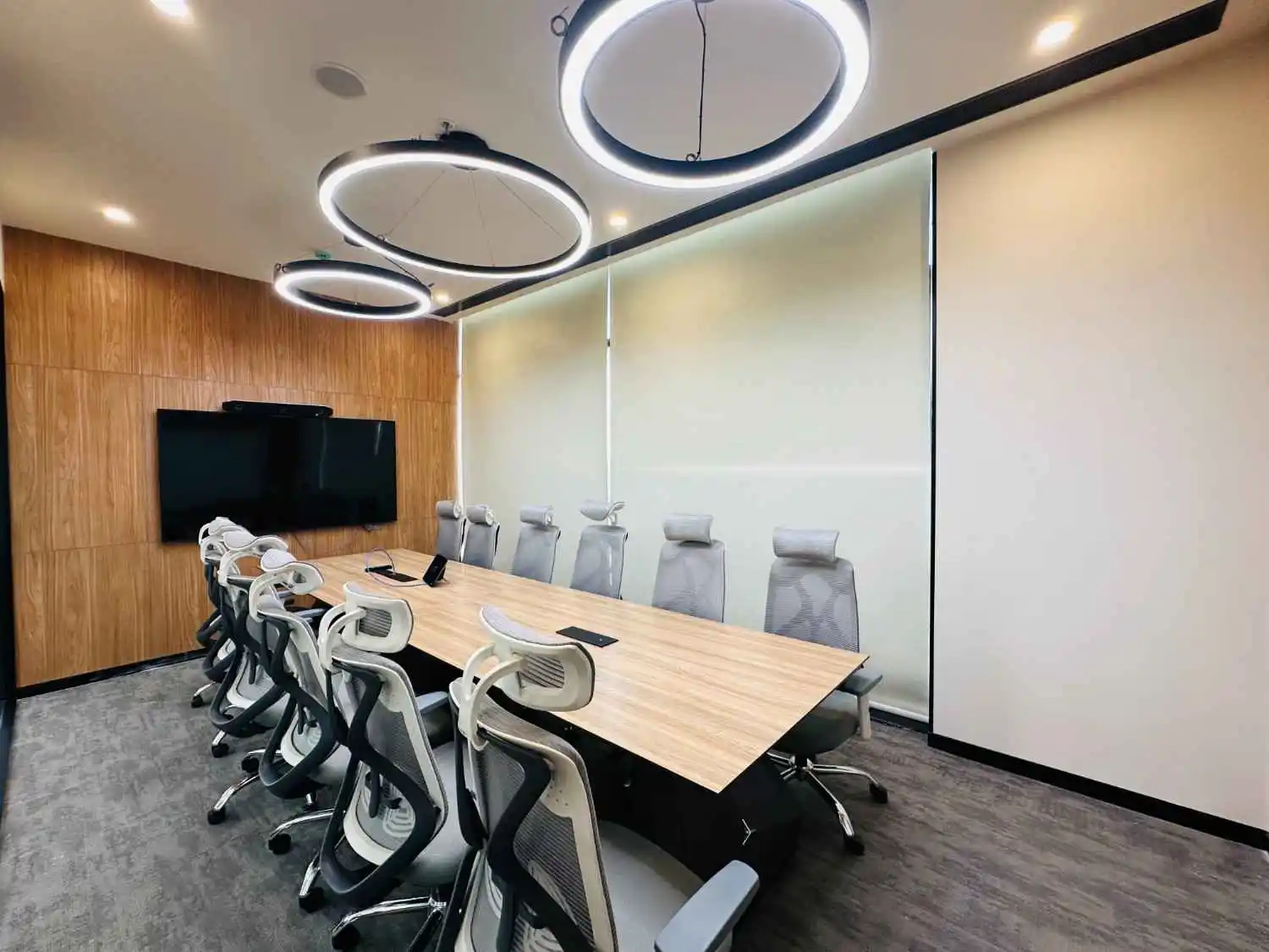 modern conference room with large meeting table ergonomic chairs and overhead circular lighting
