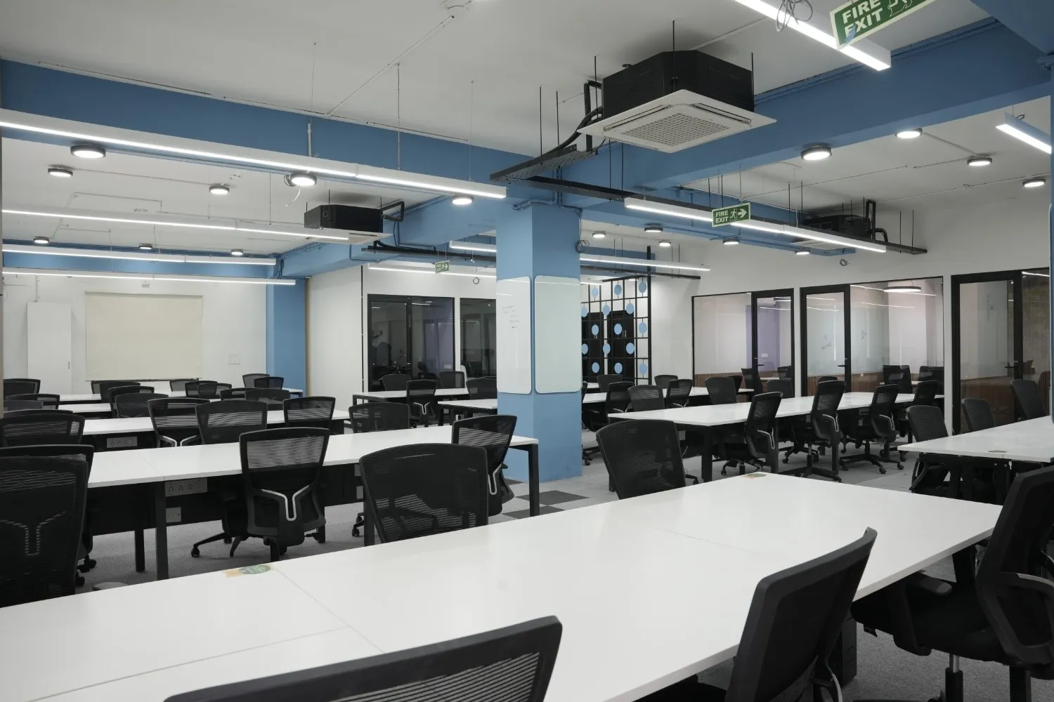 Modern open office workspace with desks, chairs, and meeting rooms in Whitefield